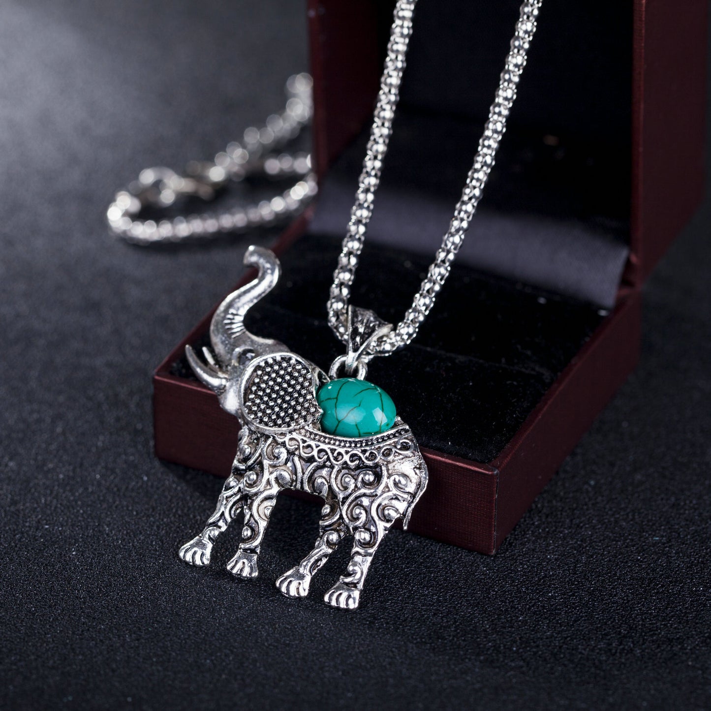 Elephant pendant necklace with silver chain and turquoise stone oval on an elephant charm
