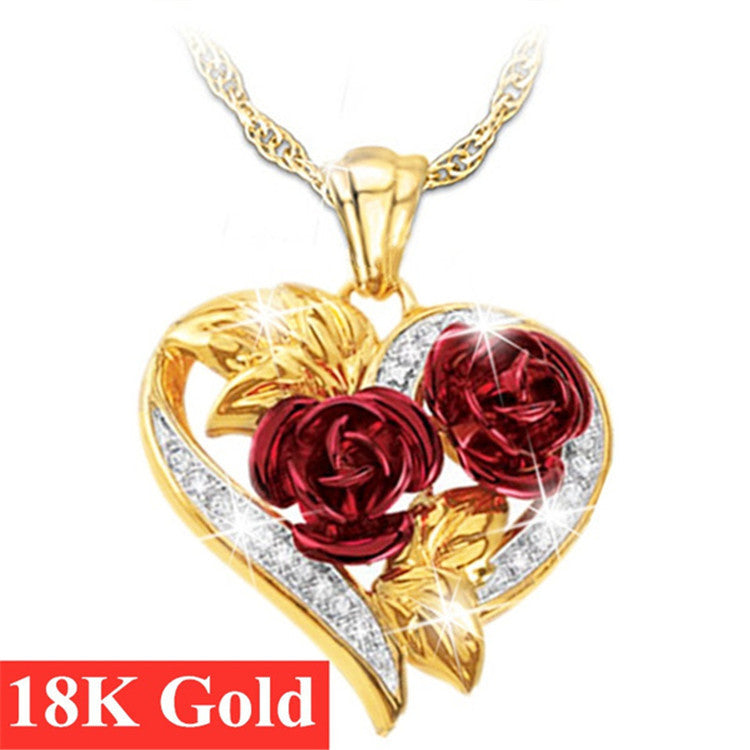 Gold heart pendant with two red rose flowers and clear stone accents