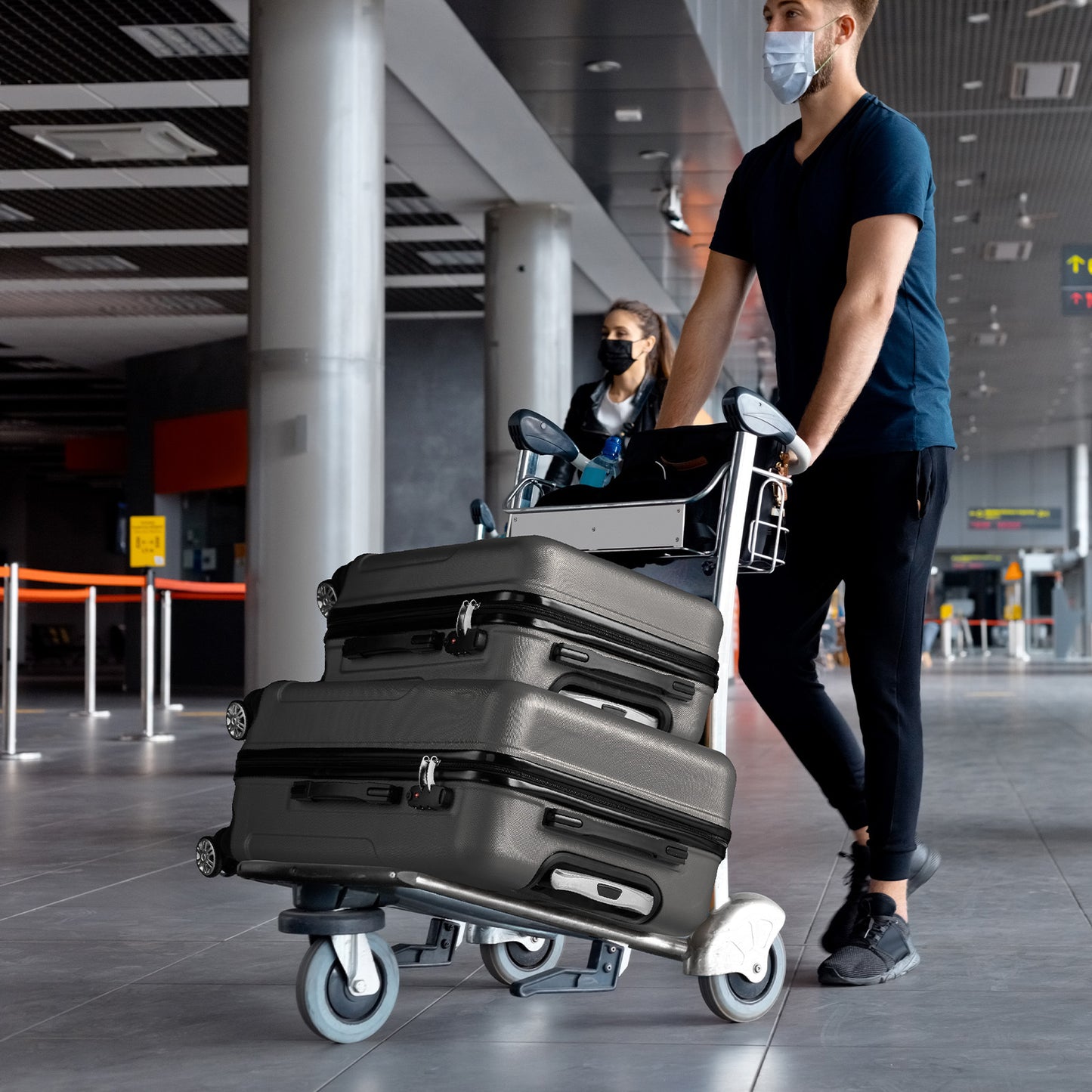 Dark grey ABS hardside suitcases stacked on a rolling cart with spinner wheels