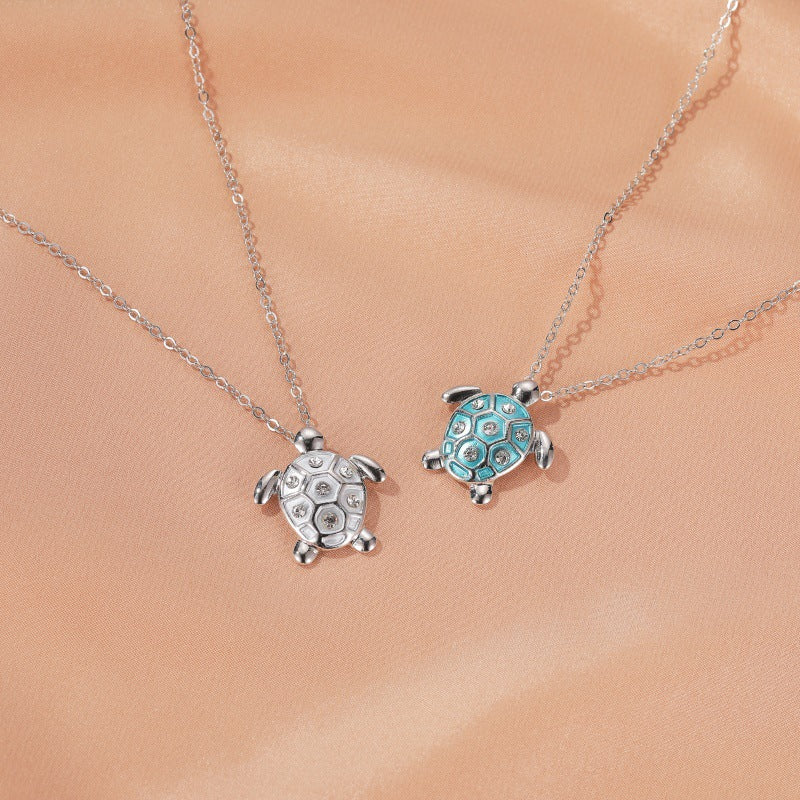 Two turtle pendant charms on silver chain: blue enamel and silver