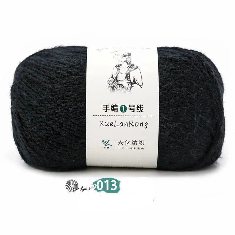 Black hand-knitted scarf yarn ball, tightly wound with white label band