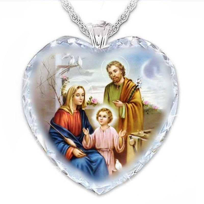 Silver heart pendant with detailed religious scene and clear crystal-style border
