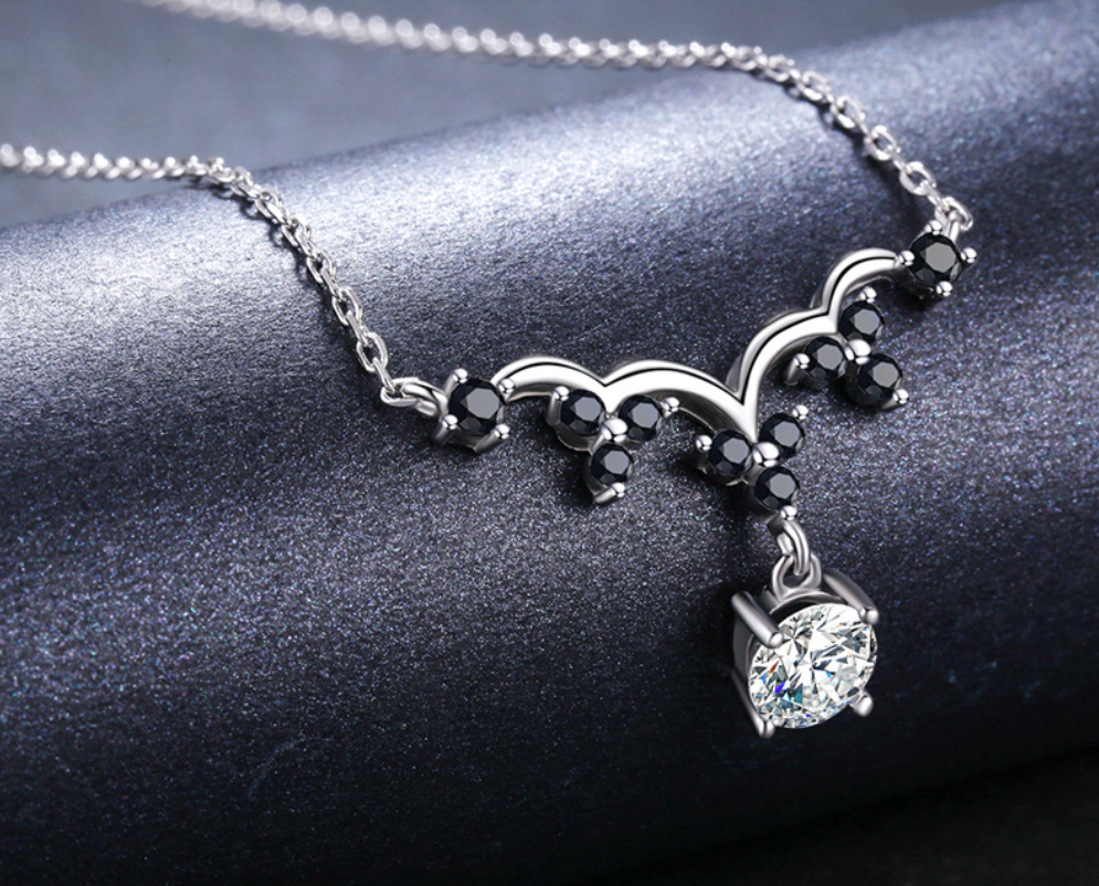 Sterling silver necklace close-up with black bead clusters and round crystal charm