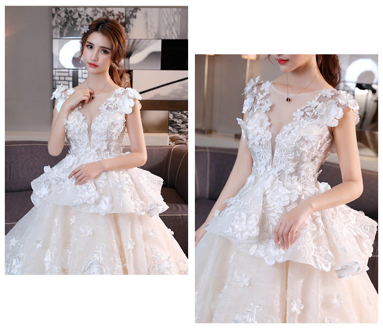 White lace bride dress close-up with floral appliqué bodice and layered sweetheart skirt