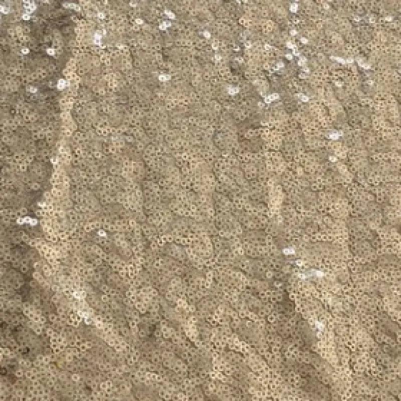 Close-up of shimmering sequins on coffee gold fabric