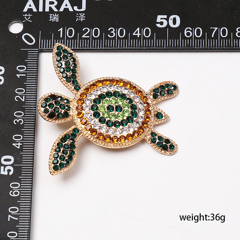 Turtle-shaped earrings with green rhinestone shell and gold-tone trim