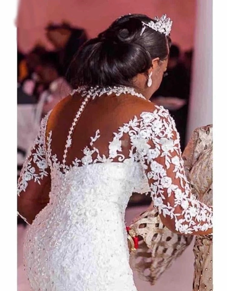 White lace back of mermaid wedding dress with long sleeves and floral appliqué veil