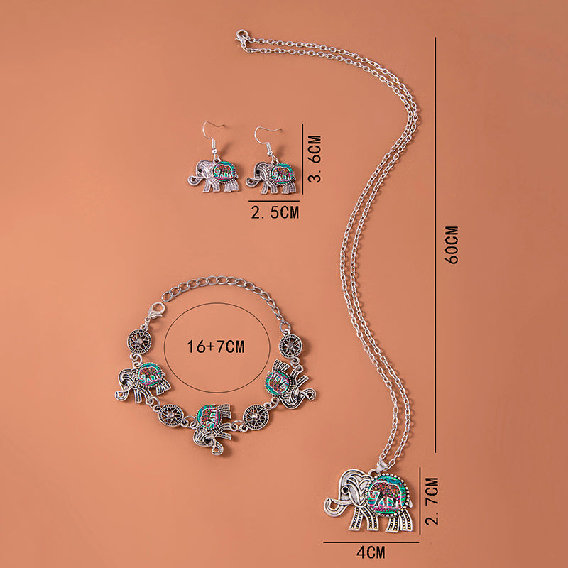 Silver elephant jewelry set flat lay: necklace chain, matching earrings, and bracelet.
