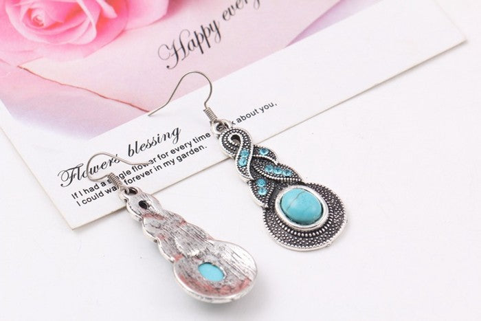 Turquoise teardrop earrings with silver-tone frames, oval stone centers, and hooks