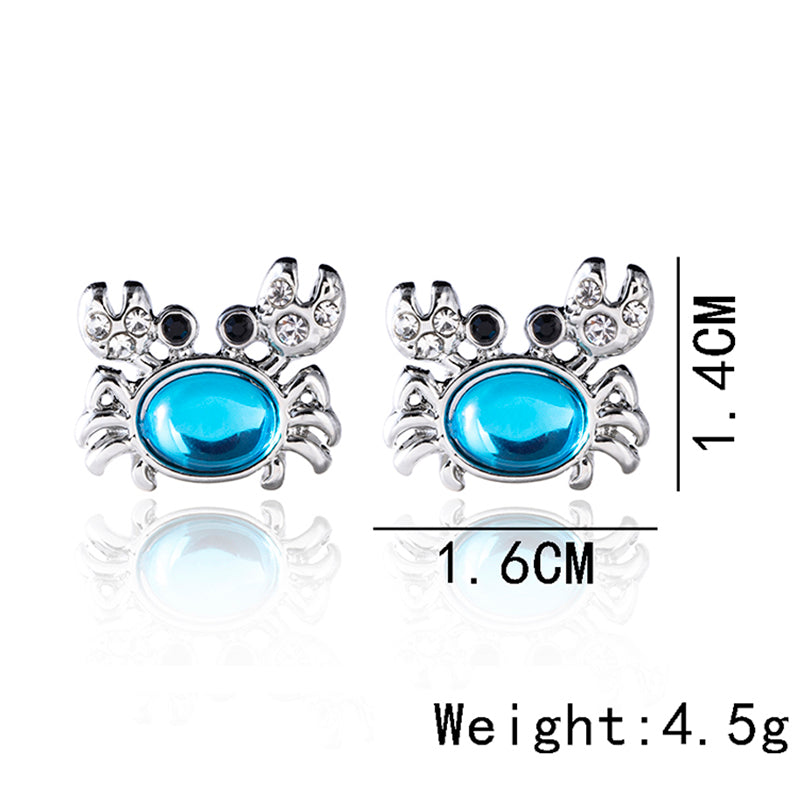 Pair of silver crab stud earrings with turquoise oval crystals and clear stone accents