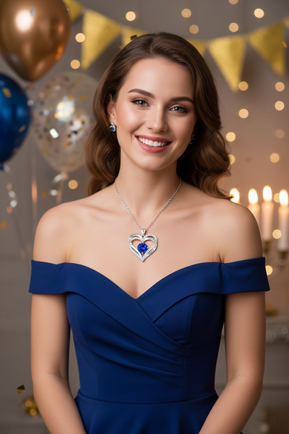 Silver heart pendant necklace with blue gemstone center on a fine chain