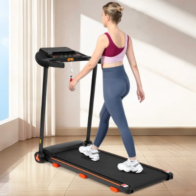 Black folding treadmill with orange side rails and running belt in an indoor room.