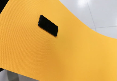 Yellow EVA yoga mat with textured grip surface and black handle tab