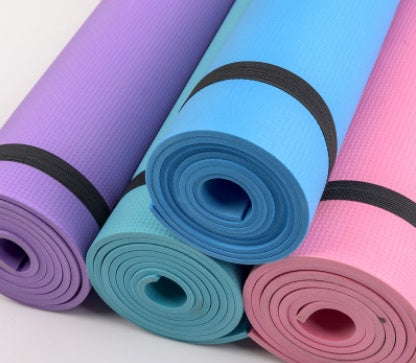 Yoga mats in purple, teal, and pink with black bands, rolled for storage