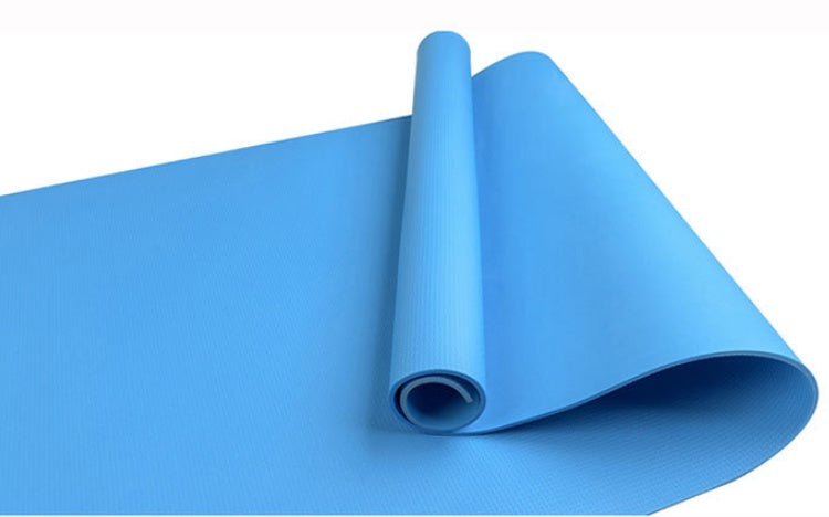 Blue fitness yoga mat, rolled with textured surface and visible open end