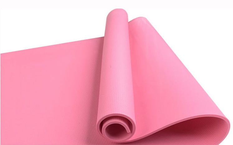 Pink fitness yoga mat, rolled with textured surface and visible open end