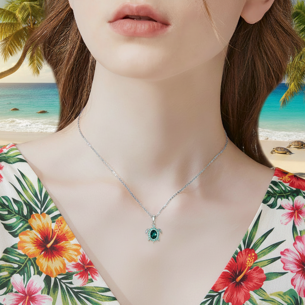 Close-up: silver turtle pendant necklace with green crystal drop on chain