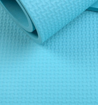 Blue yoga mat with textured embossed pattern, folded edge visible