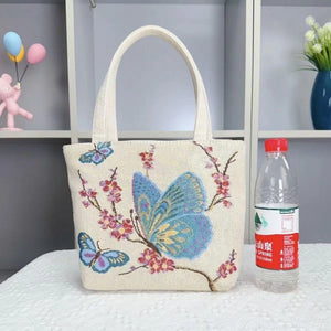 Cream canvas tote bag with blue butterflies and pink floral vine print, double-handled