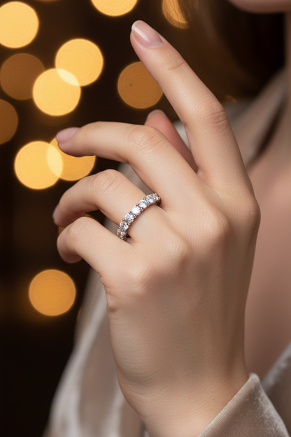 Silver ring with clear stones on finger, close-up view