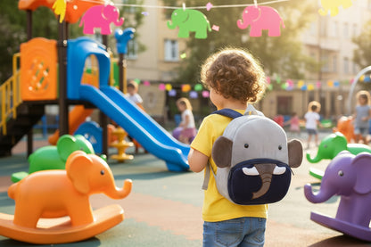 Gray plush elephant backpack with dark blue belly and trunk, padded straps, front pocket