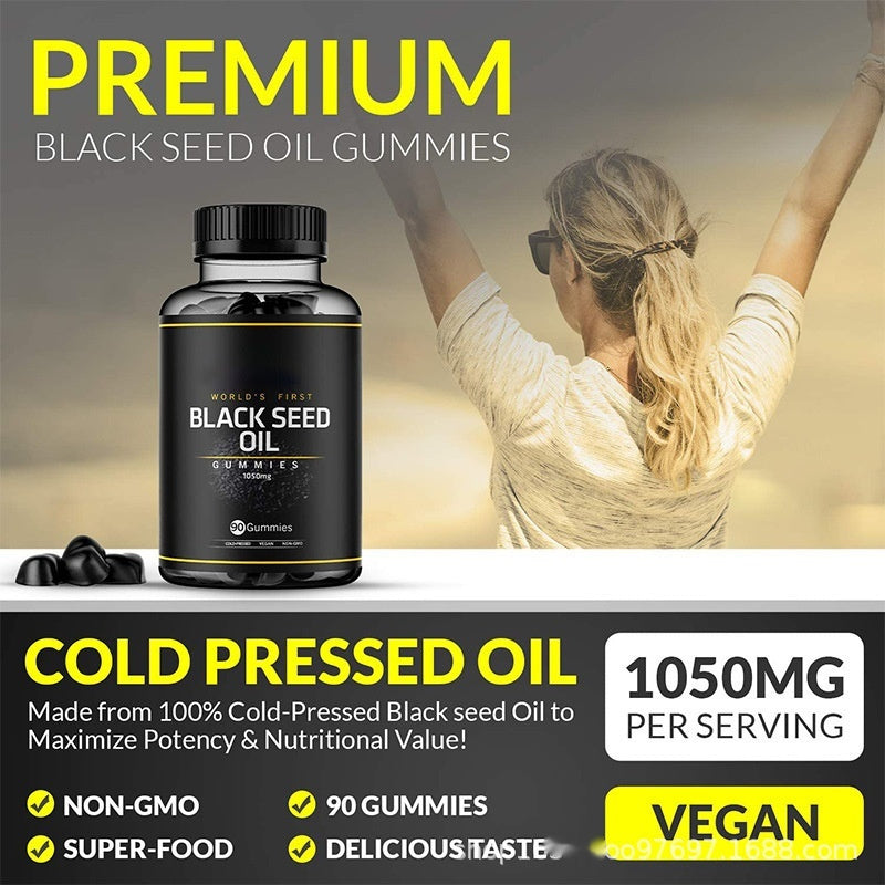 Black seed oil gummies supplement bottle with black label and scattered gummy pieces