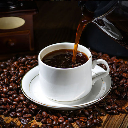 Hot black coffee in white cup with stream, on coffee beans