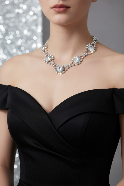 Layered rhinestone necklace on skin: silver-tone chain with oval center, round accents