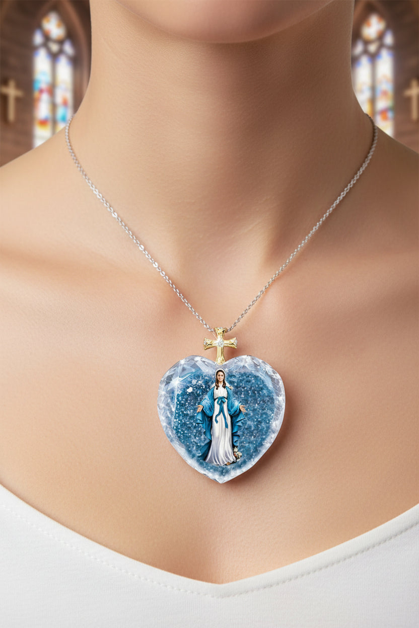 Blue crystal heart pendant with gold cross charm on silver chain, shown on neckline close-up.