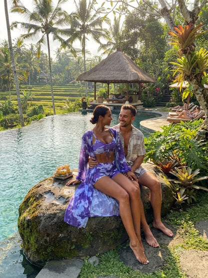 Purple patterned V-neck bikini top and matching two-piece bottoms on a woman sitting