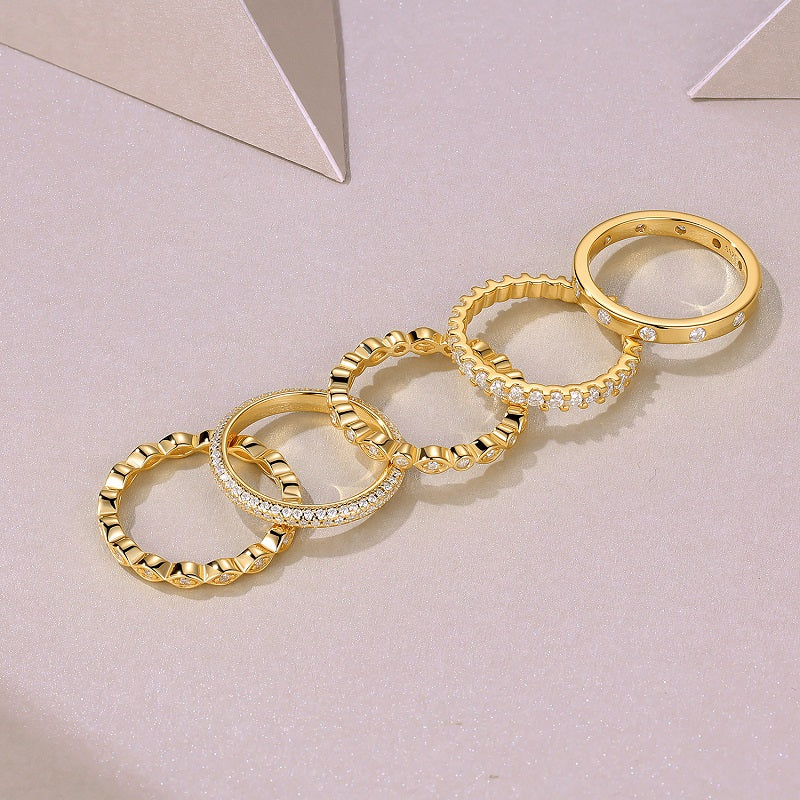 Gold-tone ring set with textured links and pavé stone accents, flat lay