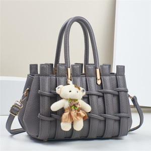 Dark gray woven shoulder handbag with teddy bear charm, top handles and crossbody strap