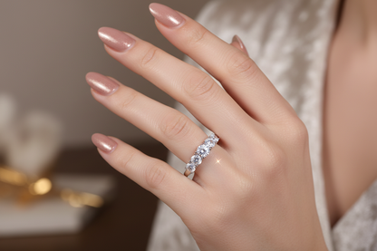 Silver moissanite ring with three clustered stones, close-up on manicured hand