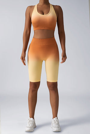 Orange seamless crop tank sports bra and high-waist biker shorts set, front view.