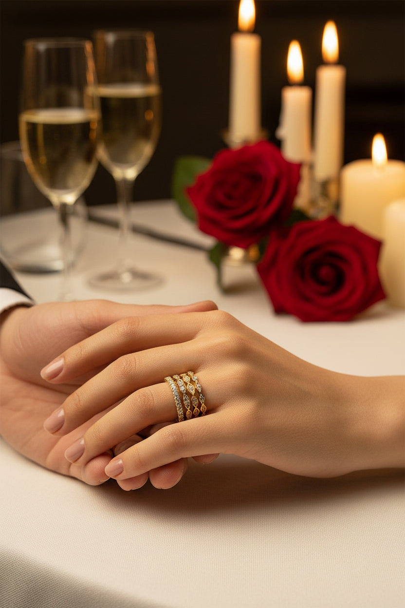 Gold-toned stacked rings on fingers, multiple bands with small clear stones