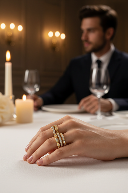 Gold-toned stacked ring with stone rows on hand resting on a table