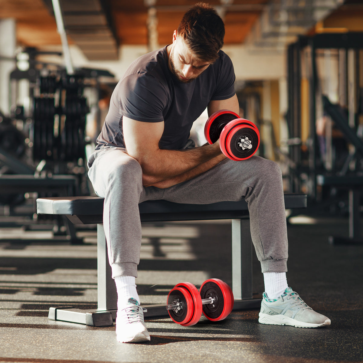 Adjustable weight set dumbbell with red plates and short bar for home training