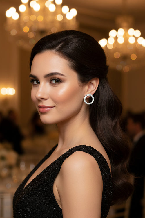 Silver moissanite stud earrings with round pavé halo, worn on ear