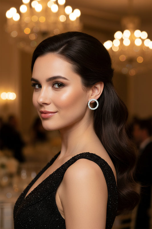 Silver moissanite stud earrings with round pavé halo, worn on ear