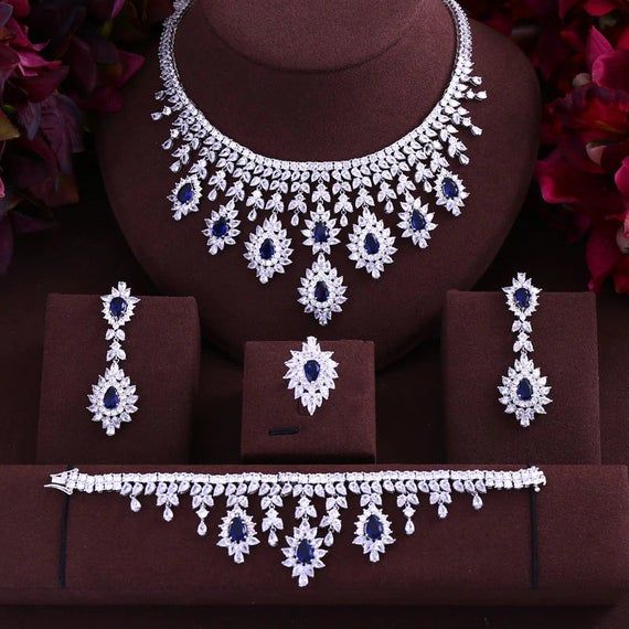 Silver-tone necklace and earring set with blue flower drop motifs and matching bracelet
